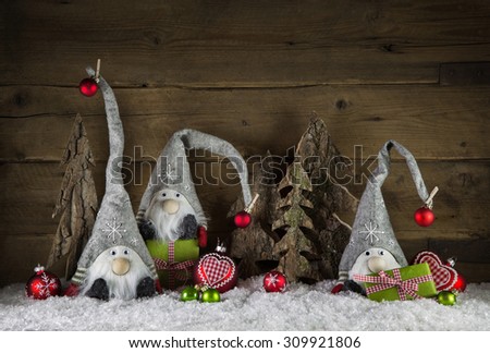 Rustic christmas decoration in country style with gnom like santa on old wooden background with green gifts.