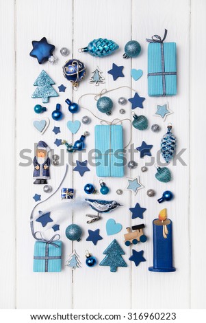Collection of blue and turquoise miniatures with presents for christmas decoration on wooden white background.