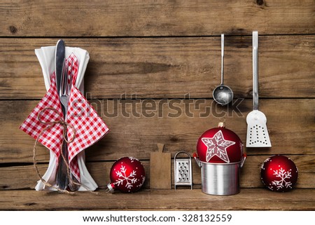 Dinner on christmas eve. Old wooden background with red white checked cutlery and dishes for decoration.