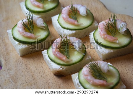Canape with cream cheese, cucumber and shrimp.