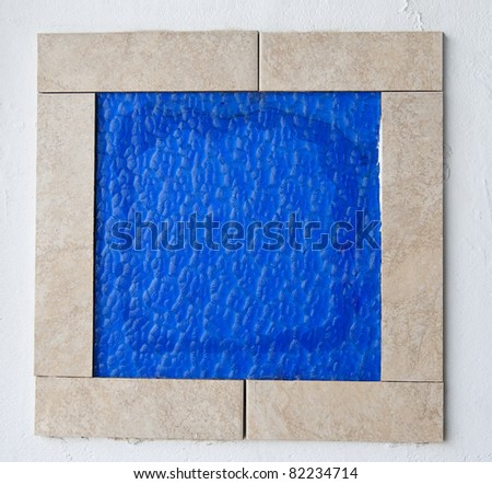 Blue glass tile framed on the wall