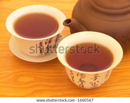 Tea for two. Two teacups close to each other and a teapot.