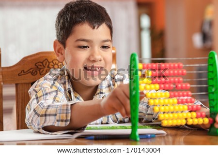 Little boy accounts through abacus. Selective focus on little boy.