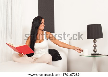 Beautiful woman sitting on the sofa and  reading a book