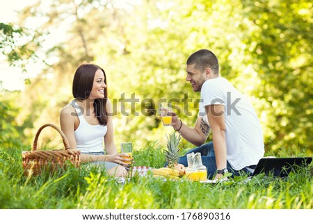 Happy young couple having a picnic in park