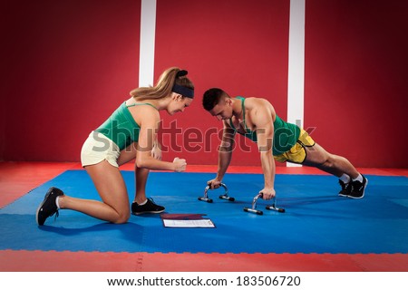 Women trainer motivates men who do push-ups