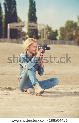 young woman shooting video with old analog camera