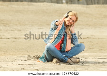 Happy woman with thumbs up  listening to music with headphones