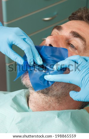 Patient at the dentist with a rubber dam