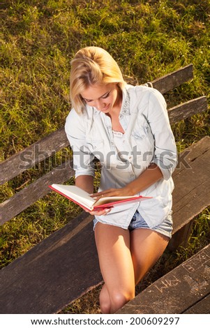 Young woman reading a book in the nature