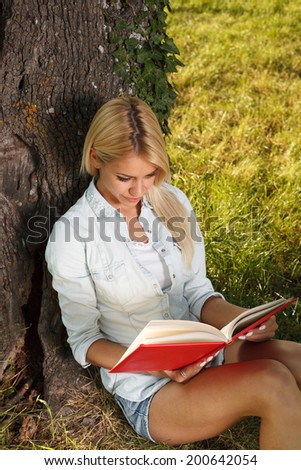 Young woman reading a book in the nature