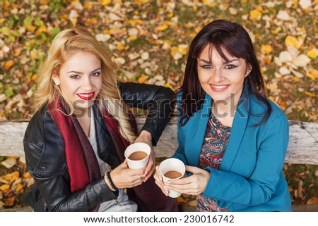 Two women drinking coffee in the park