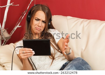 Young woman listening to music via digital tablet and has a problem