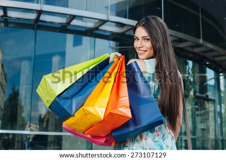 Attractive woman posing with shopping bugs in front of the shopping center