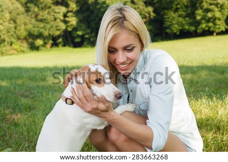 Young woman holding dog in the arms. Selective focus on woman face.