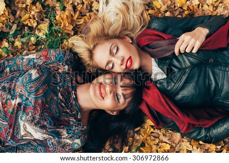 Two women head to head lying in the leaves
