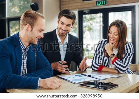 Small group of young people at a business meeting in a cafe. Selective focus on man in the middle and woman.
