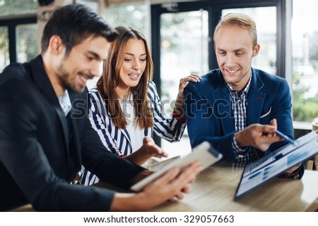Small group of young people at a business meeting in a cafe. Selective focus on woman and blonde man.