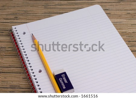 pencil and eraser in line with college rule paper