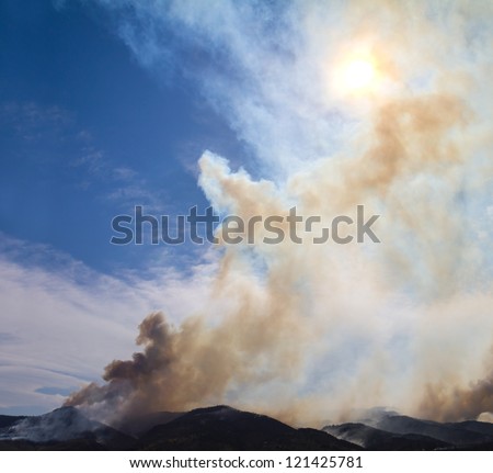 Wildfire smoke rises from burning mountains in Colorado