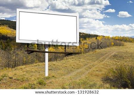 Blank billboard sign on dirt trail through a Fall aspen forest in the Colorado wilderness