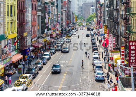 NEW YORK CITY - CIRCA JULY 2015: Tourists shop at businesses along a busy street in historic Chinatown during 4th of July festivities in Manhattan, New York City.