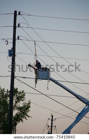 HOLLY SPRINGS, NC, USA - APRIL 16: After a tornado caused severe damage, a repair man is fixing the power lines in Holly Springs on April 16, 2010 in Holly Springs, NC, USA