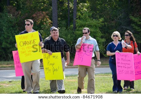 APEX, NC, USA - SEPTEMBER 14: People carrying political signs, when President Barack Obama visits Westar company on September 14, 2011 in Apex, NC, USA