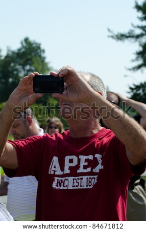 RALEIGH, NC, USA - SEPTEMBER 14: An unidentified man from Apex takes pictures when President Barack Obama arrives for his visit at Westar company on September 14, 2011 in Raleigh, NC, USA