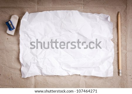 Writing concept - crumpled up paper wads with a sheet of white paper and pencil
