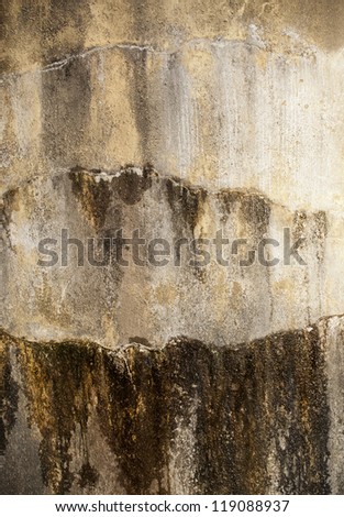 Concrete wall of a water tank with water seeping out as background texture