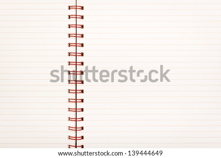 Notebook with pale lined paper and red metal binding as background