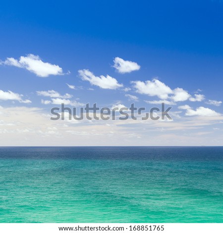 Bright blue sea beneath the blue sky with clouds