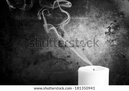 Smoke trails in smooth lines from a blown out candle with a vintage background in black and white
