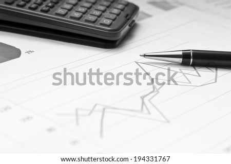 Graphs, calculator and paper statements for finance concept