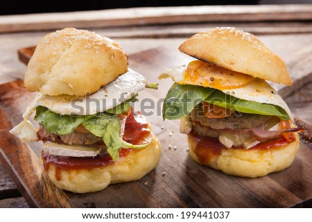 Home made gluten free mini burgers or sliders with beef, egg, lettuce, cheese and sauce