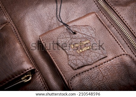 Leather tag with Full Grain Leather text embossed in gold