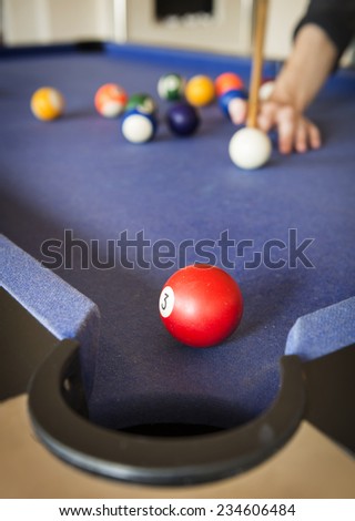 Playing pool on a pool table with billiard balls