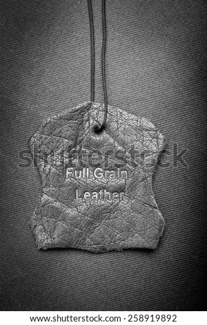 Leather tag with Full Grain Leather text embossed in black and white