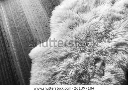 Lambs wool sheepskin on a timber floor in black and white