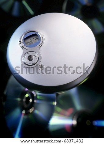 A stylish portable CD player with CD\'s in the background