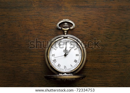Antique pocket watch on a wood board