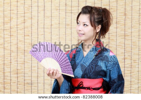 Young japanese woman in traditional clothes of kimono with japanese fan