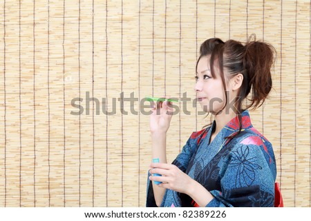 Japanese woman in traditional clothes of Kimono, blowing soap bubbles