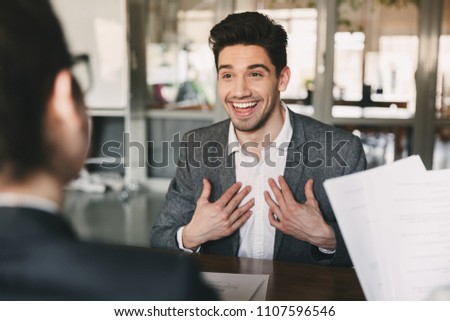Business, career and placement concept - surprised caucasian man 30s rejoicing and showing at himself when hiring during job interview with employees in office