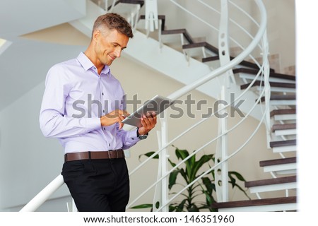 Happy Mature Businessman Using His Tablet