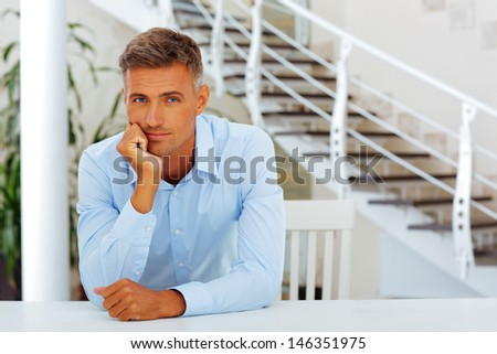Happy handsome mature man in formal cloths at home