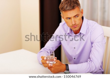 Handsome pensive man drinking water