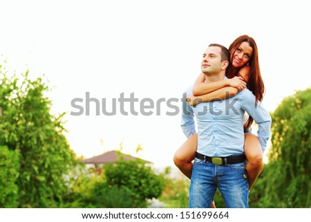 Happy woman jumped on man\'s back