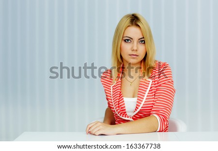 Young serious woman sitting at the table in office